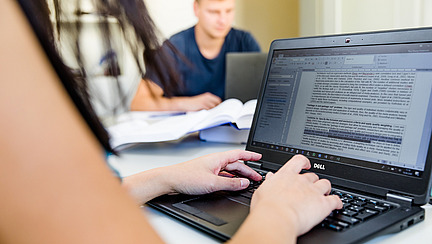 Menschen arbeiten an einem Laptop