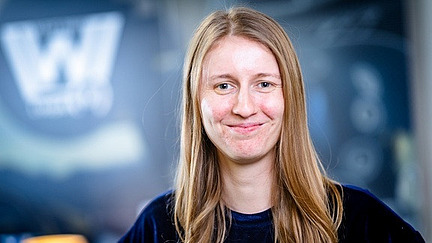young woman with long blond hair smiles into the camera