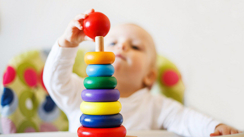 Kind mit Greifspiel Kind mit Greifspiel