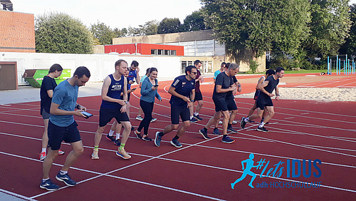 Eine Gruppe von Läuferinnen und Läufern an der Startlinie einer Laufbahn