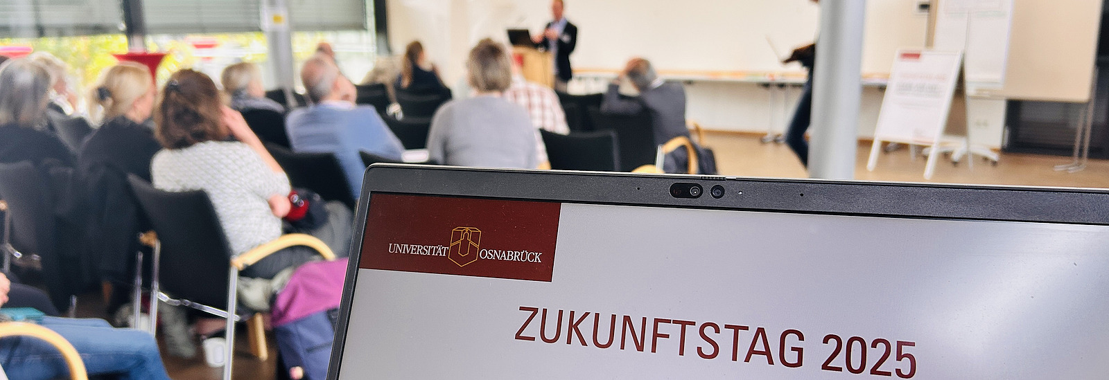 Laptop mit Tagungstitel vor Plenum