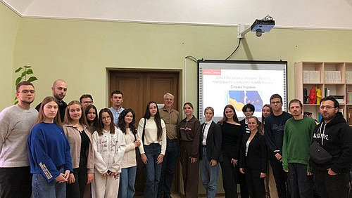 Seminargruppe in Chernivtsi Prof. Ulrich Schneckener im Gruppenfoto mit ukrainischen Studierenden des Seminars in Chernivtsi; im Hintergrund sind die Powerpoint-Folien mit ukrainischer Flagge zu sehen