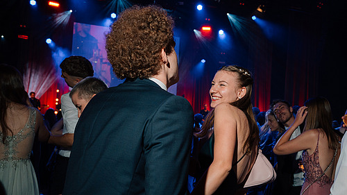 Festively dressed ball guests on a dance floor