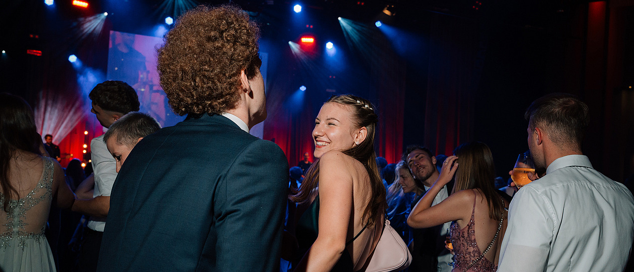 Festively dressed ball guests on a dance floor