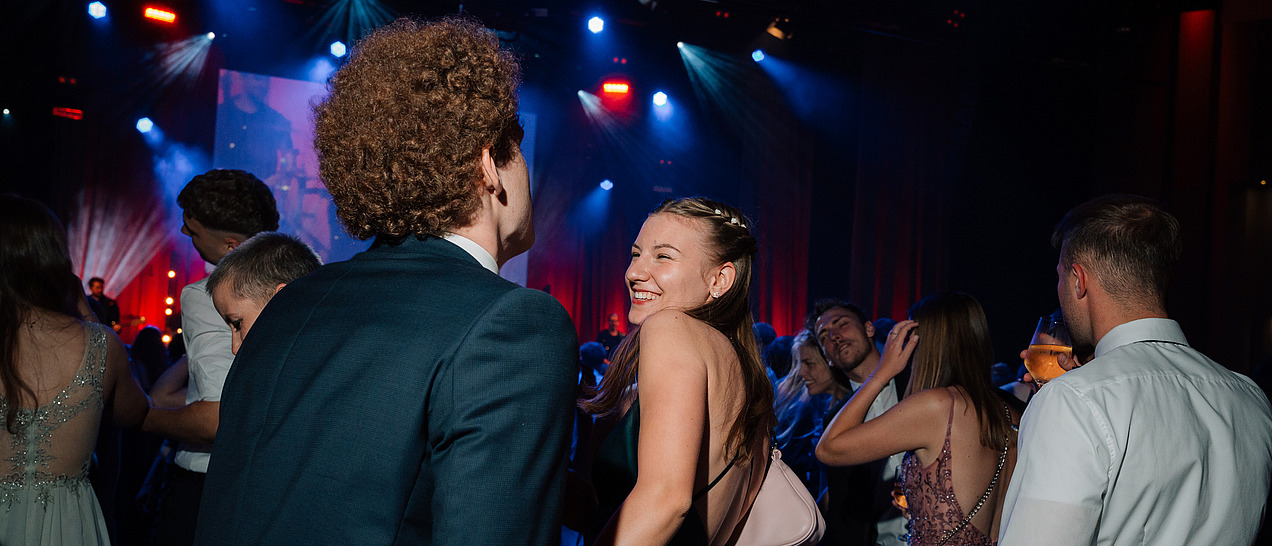 Festlich gekleidete Ballgäste auf einer Tanzfläche