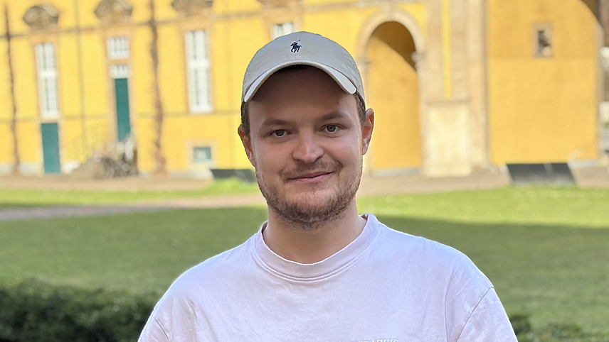 Foto von Luca Wijsbeek vor dem sonnigen Schloss der Universit&auml;t Osnabr&uuml;ck