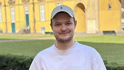 Foto von Luca Wijsbeek vor dem sonnigen Schloss der Universit&auml;t Osnabr&uuml;ck