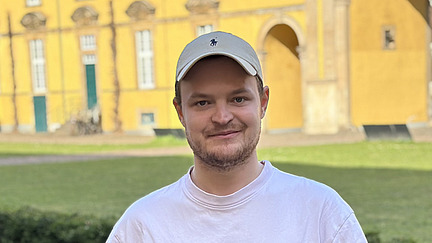 Foto von Luca Wijsbeek vor dem sonnigen Schloss der Universit&auml;t Osnabr&uuml;ck