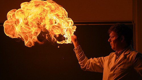 Person with safety goggles lets flame rise