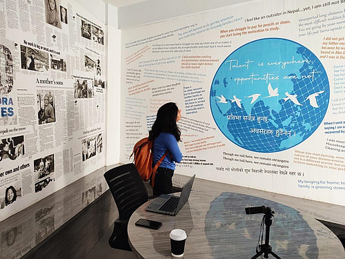 A woman with her back to the camera in front of large information walls.