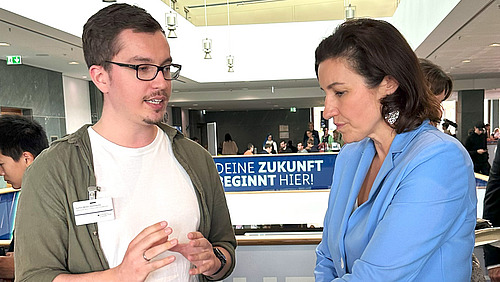 Ein Mann und eine Frau im Gespräch auf einem Messestand