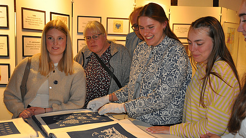 Eine Gruppe von Frauen betrachtet interessiert ein Ausstellungsst&uuml;ck.