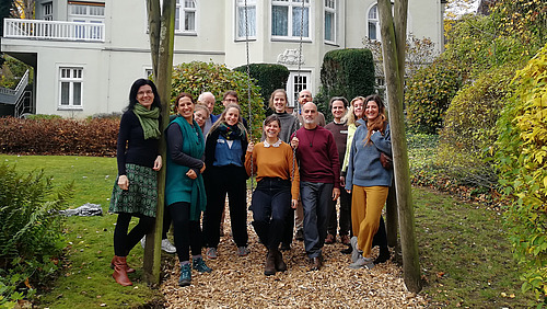 Gruppe des Inner Dimensions Workshop versammelt im Garten um eine Schaukel