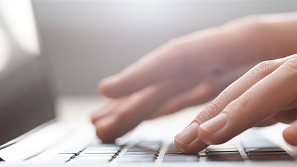 Hände tippen auf einer Tastatur