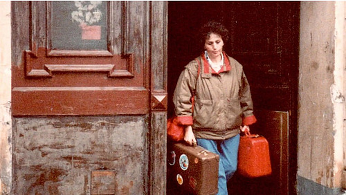 Screenshot aus Film, Frau verlässt mit Koffer Haus