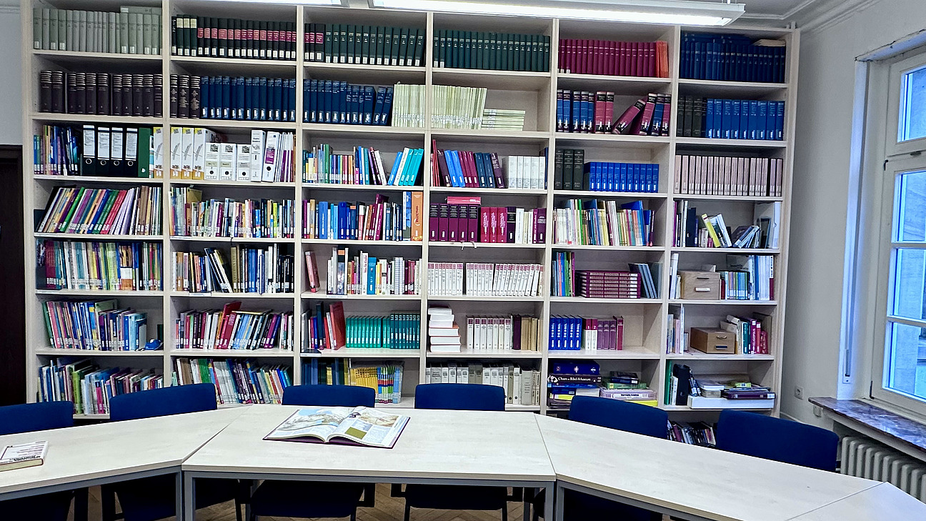 Gro&szlig;es B&uuml;cherregal mit einem Tisch im Vordergrund