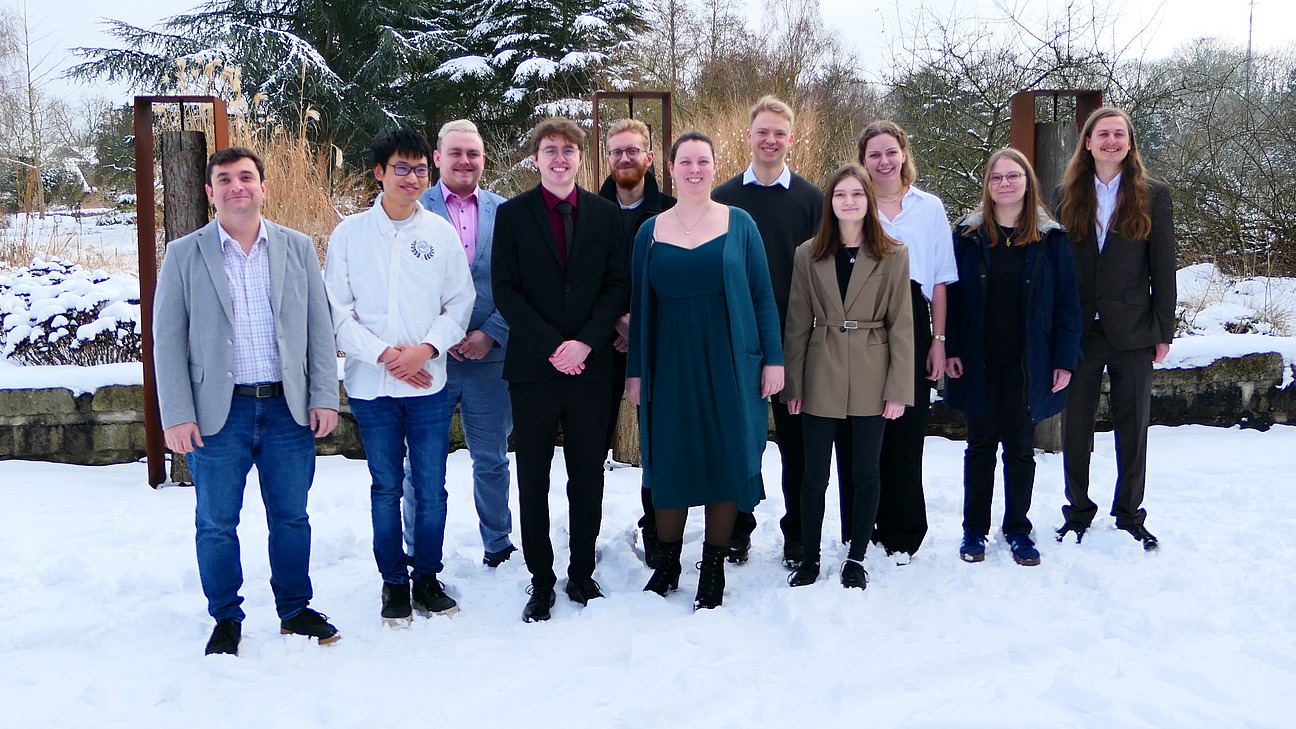 Elf Personen haben sich im Schnee f&uuml;r ein Gruppenfoto aufgestellt.