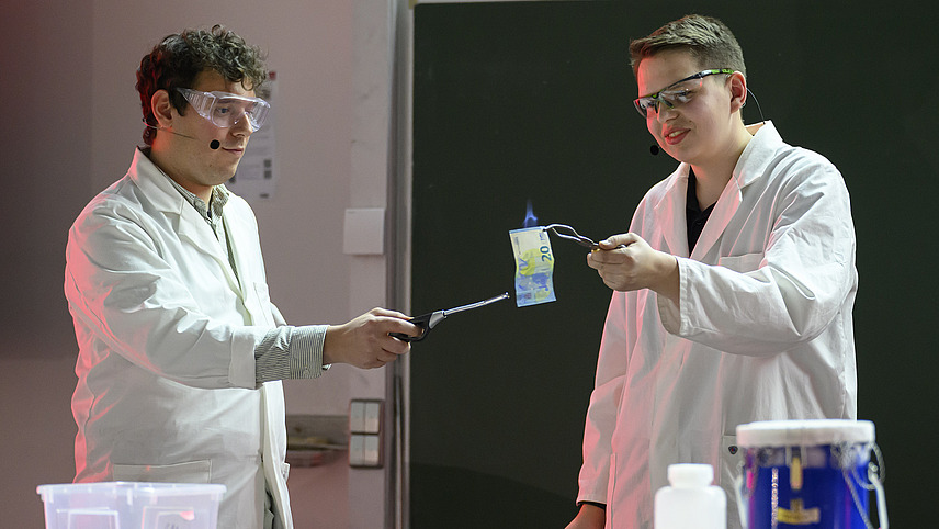 Personen in wei&szlig;en Kitteln unternehmen chemische Experimente