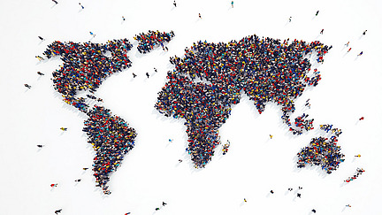 People standing together form a world map against a white background.