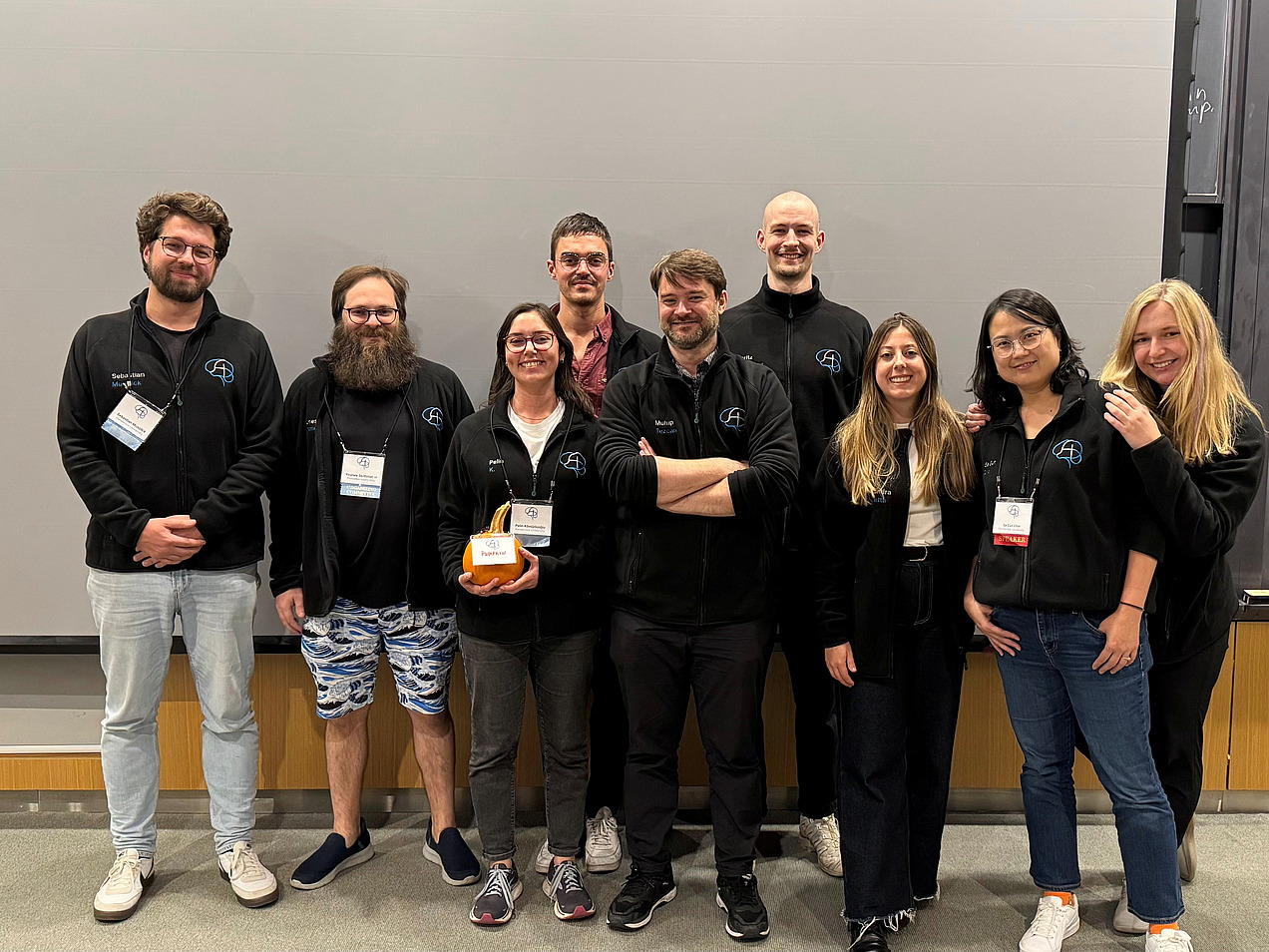 People in front of a wall look into the camera.