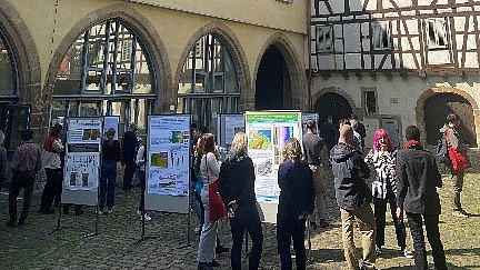 Besucher schauen sich Plakate im Freien an
