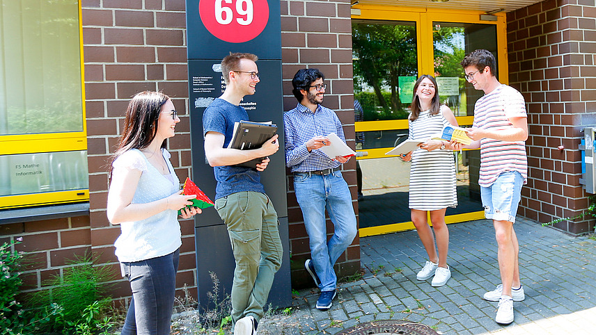 Ein paar Studierende stehen vor dem Mathematik Gebäude der Universität
