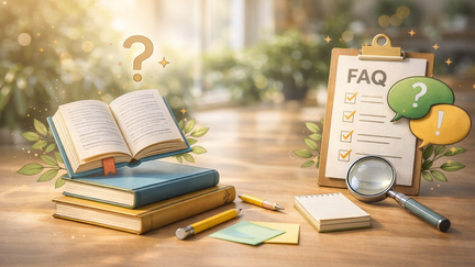 Fotorealistisches Symbolbild f&uuml;r h&auml;ufige Fragen zum Studienbeginn: Auf einem Holztisch liegen ge&ouml;ffnete B&uuml;cher, ein Notizblock, Stifte und eine Lupe. Daneben steht ein Klemmbrett mit Checkliste, erg&auml;nzt durch zwei farbige Sprechblasen mit Frage- und Ausrufezeichen vor hellem, unscharfem Hintergrund.