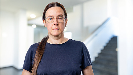 A woman looks directly at the camera