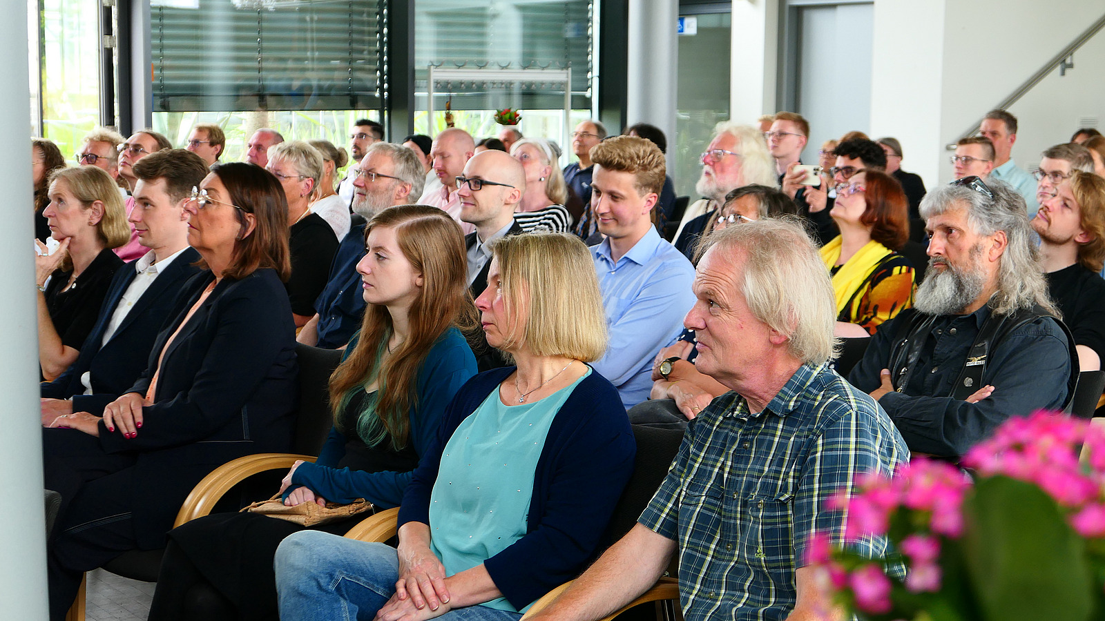 Viele Personen sitzen in einem Vortragsraum.