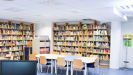 Bibliothek mit Tischen und Computer.