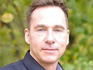 Ein Mann l&auml;chelt in die Kamera.