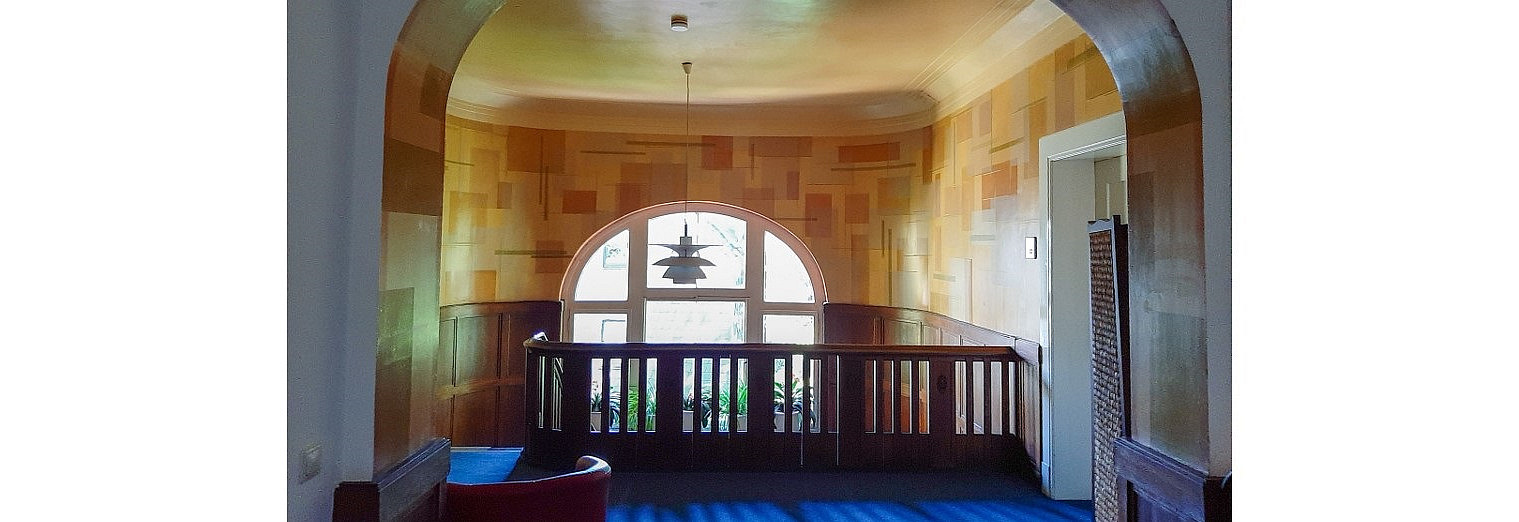 Arched passageway in the hallway, with a view of the window front in the stairwell