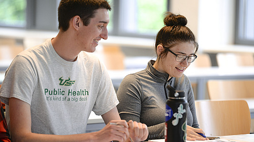 Zwei Studierende sitzen an einem Tisch in einem Deutschkurs.