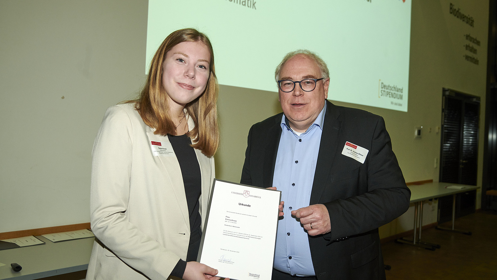 Mehrere Personen auf Bühne bei Urkundenübergabe