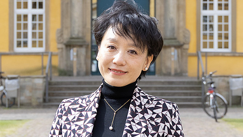 Frau Dr. Bin Qu steht vor dem Schloss