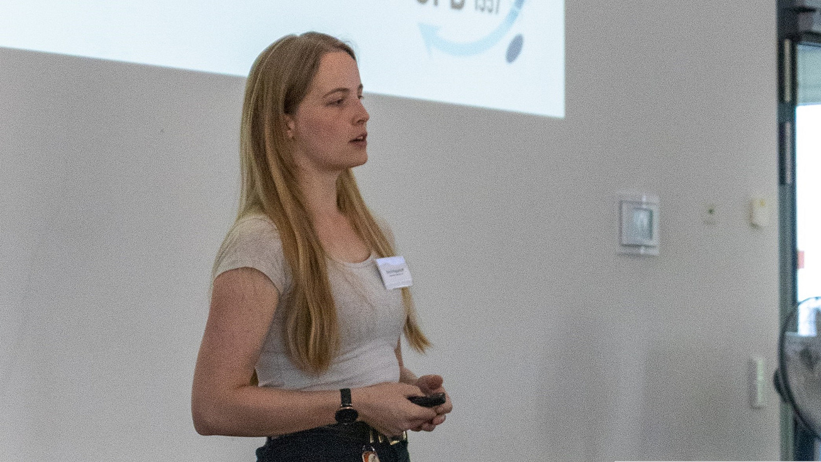 Eine junge Frau mit Pointer in der Hand h&auml;lt einen Vortrag