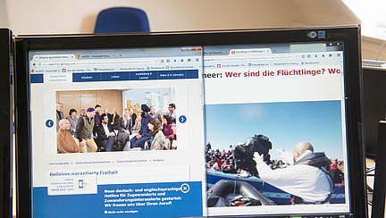 Laptopbildschirm mit verschiedenen Browserfenstern zum Thema Migration/Flucht