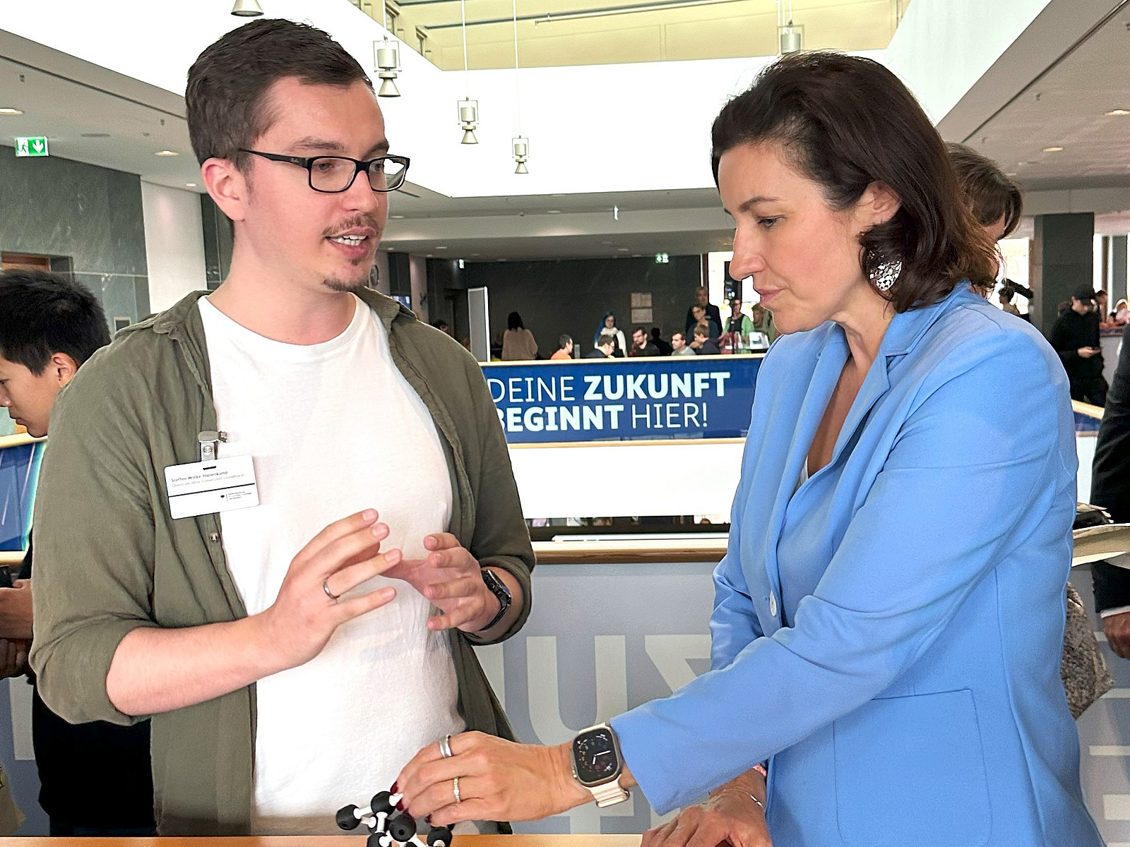 Ein Mann und eine Frau im Gespräch auf einem Messestand