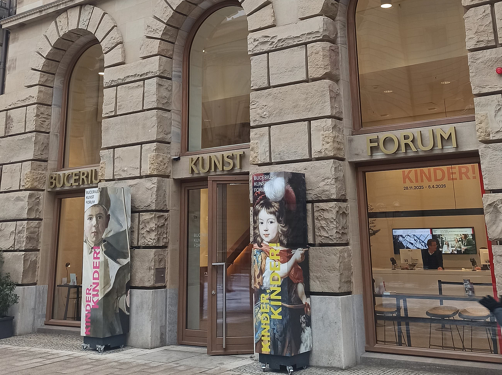 Das Bild zeigt den Eingang in ein Museum mit bodentiefen Fenstern und einer gro&szlig;en Glast&uuml;r. 