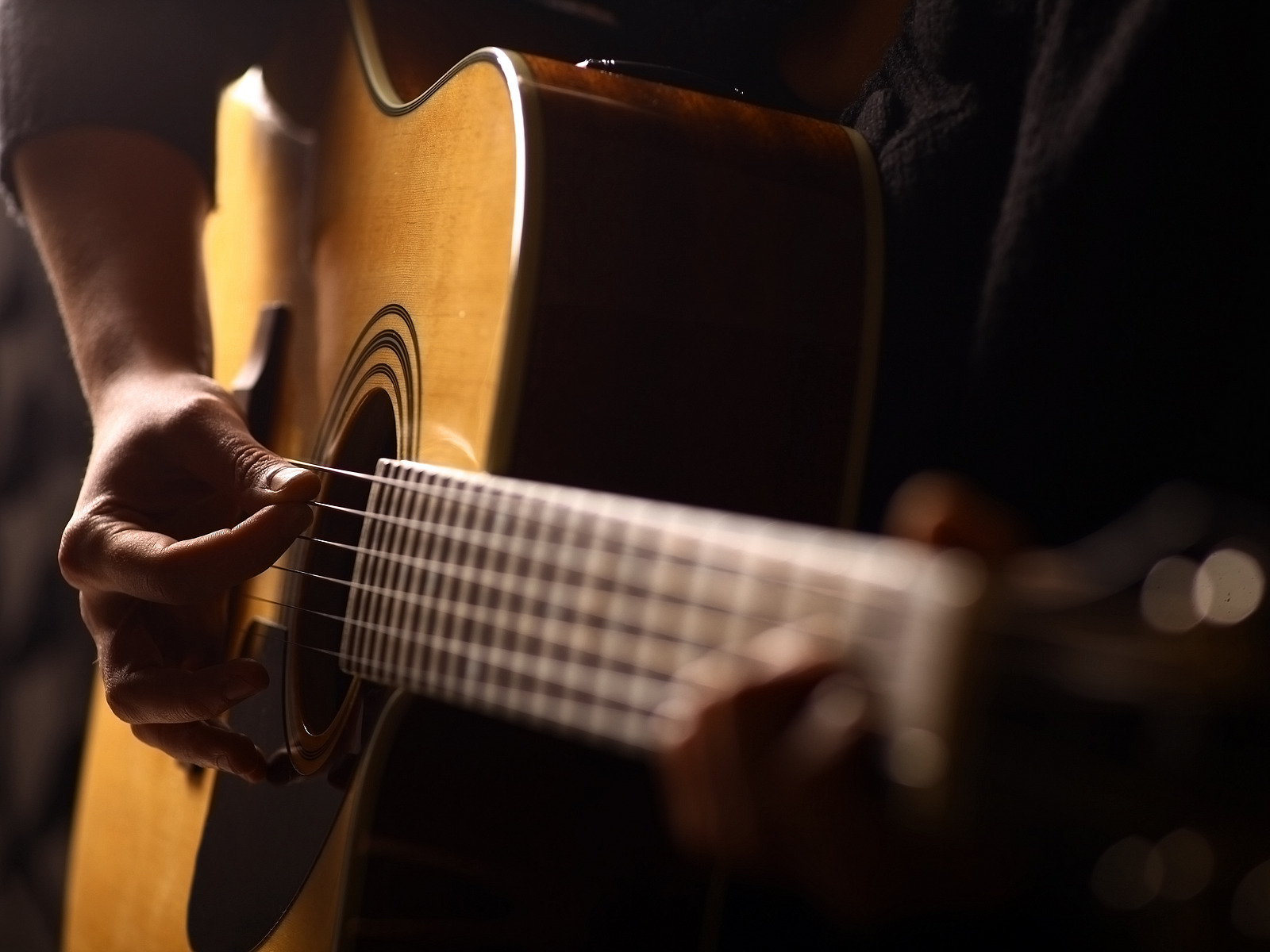 Eine Person spielt Akustikgitarre. 