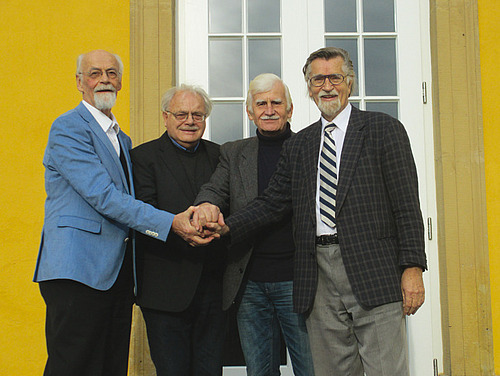 Men look into a camera.