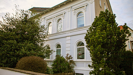 Geb&auml;ude 26 der Universit&auml;t, dem Institut f&uuml;r Erziehungswissenschaften. Es hat eine wei&szlig;e Fassade und ist von der Gr&ouml;&szlig;e eines Ein-Familienhauses. Es handelt sich um einen gut erhaltenen Altbau mit vielen Verzierungen.