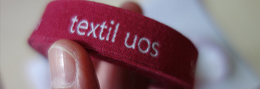 Rolle mit Webetiketten mit Schriftzug textil uos