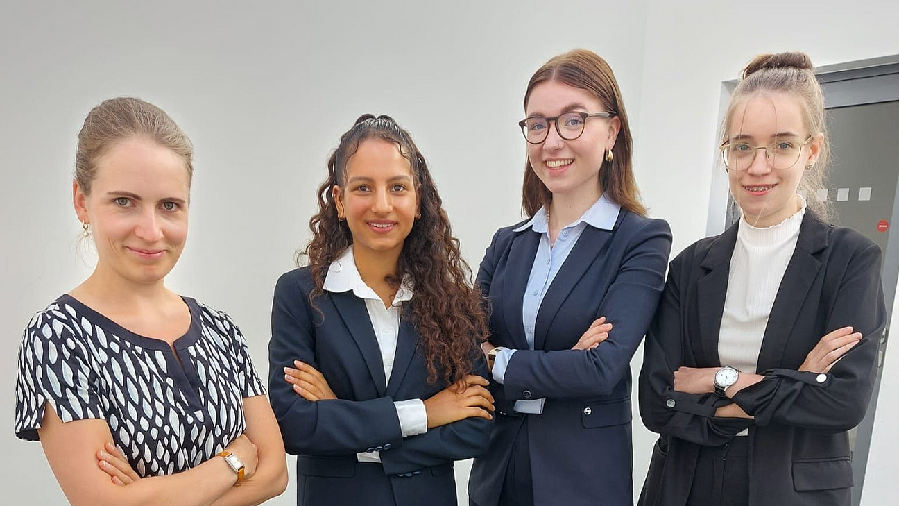 Vier Frauen in f&ouml;rmlicher Kleidung mit verschr&auml;nkten Armen nebeneinander stehend