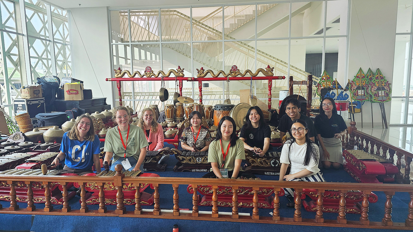 Eine Gruppe von Studierenden posiert vor einer traditionellen javanischen Gamelan-Anlage. Die Instrumente sind kunstvoll verziert und die Gruppe scheint eine kulturelle Erfahrung zu machen.
