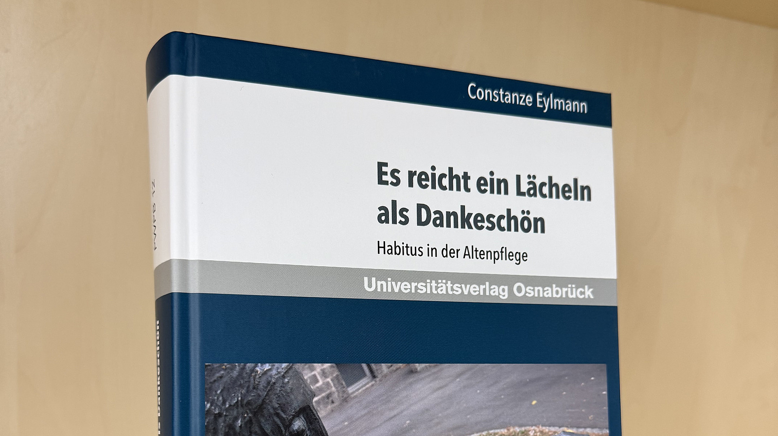 Ein Fachbuch von Constanze Eylmann mit dem Titel "Es reicht ein L&auml;cheln als Dankesch&ouml;n. Habitus in der Altenpflege" steht in einem Regal.