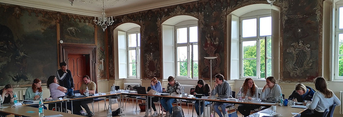 Studierende in einem alten sch&ouml;nen Seminarraum mit hohen Decken und Kronleuchtern