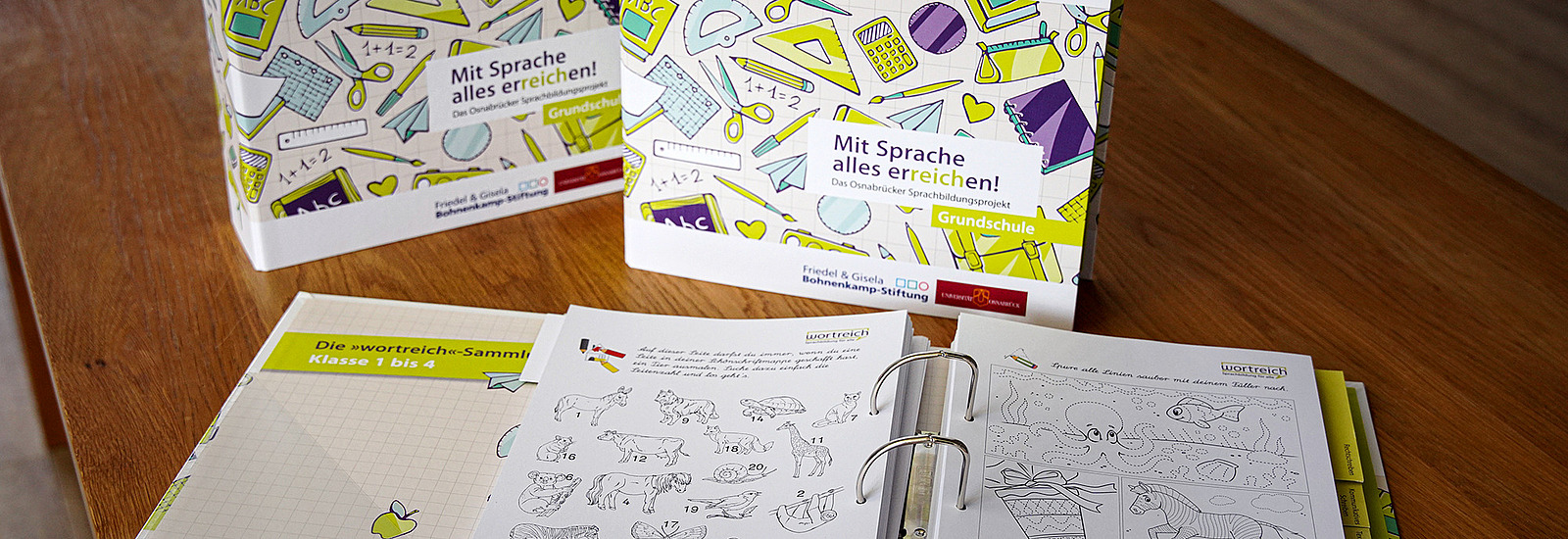 Ein aufgeschlagener Wortreich-Ordner liegt auf einem Tisch. Man kann Abbildungen von verschiedenen Tieren erkennen.