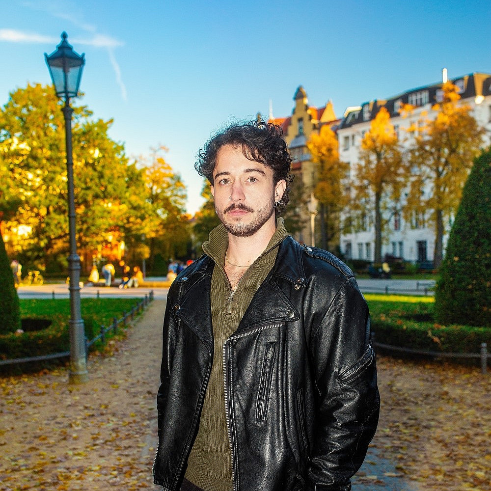 Das Bild zeigt Gen Eickers in einem Park und zur Kamera lächelnd.