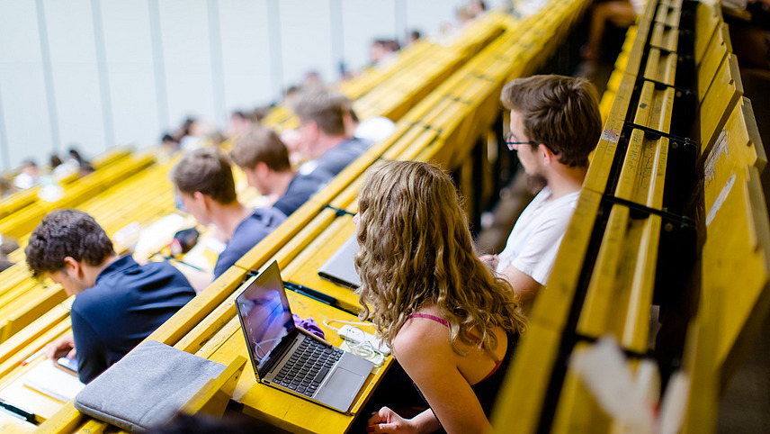 Blick über die Sitzreihen in einem Hörsaal auf Studierende.